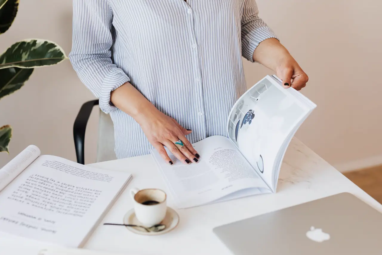A stack of printed magazines on a desk.